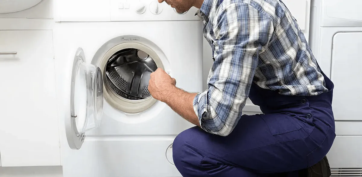 Handyman inspecting a dryer drum and internal parts for repair in Omaha, NE