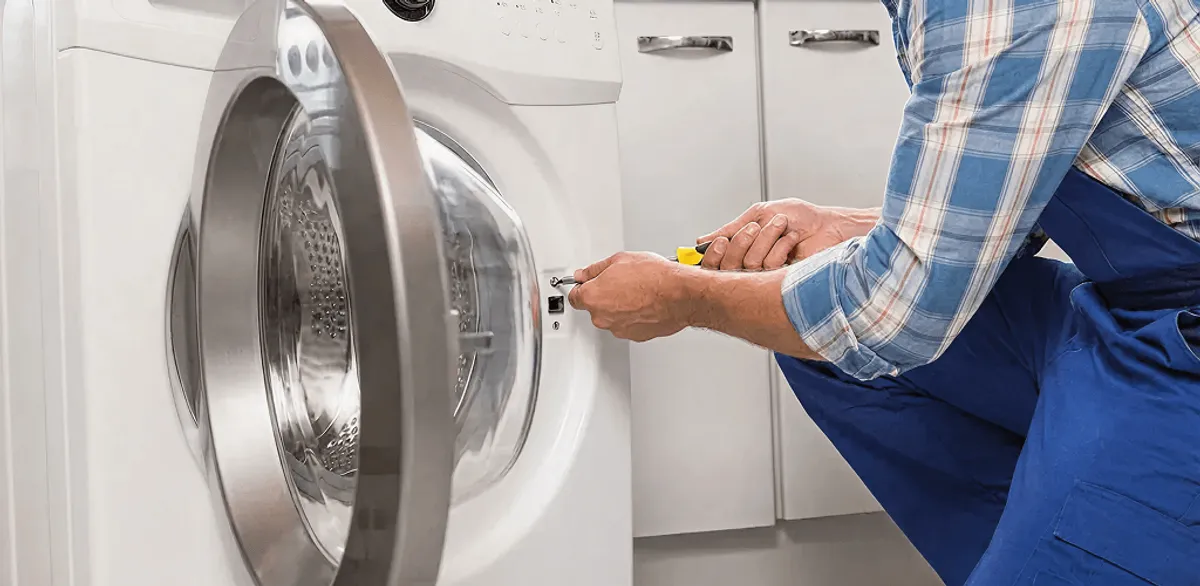 Handyman repairing a clothes dryer and checking electrical connections in Omaha, NE