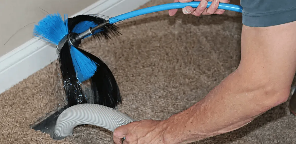 Dryer vent cleaning technician brushing lint from a vent line in Omaha, NE